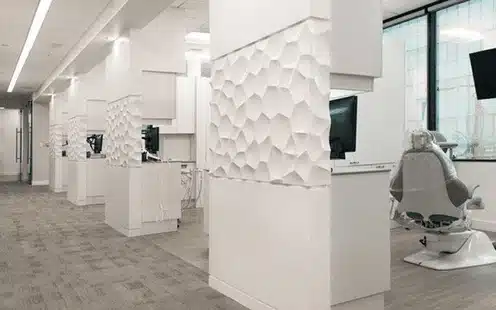 Modern dental office interior with white walls, treatment stations, and contemporary design elements.