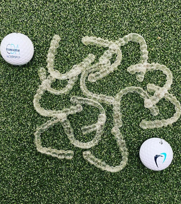 Golf balls on artificial green turf with winding path between them.