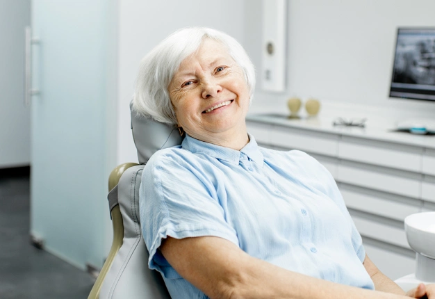 Senior woman smiling in dental chair at modern dental office